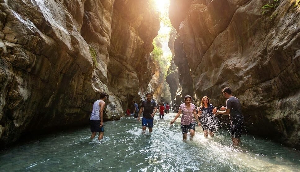 tourists walking through the water inside robber