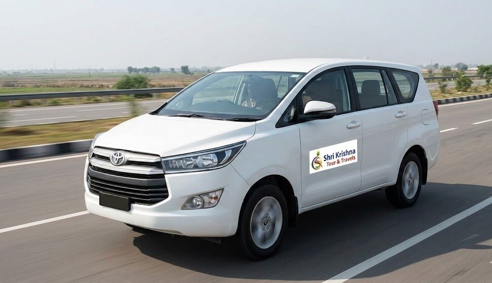 a premium shri krishna tour & travels innova taxi driving on the yamuna expressway at sunrise, with the logo visible on the door.