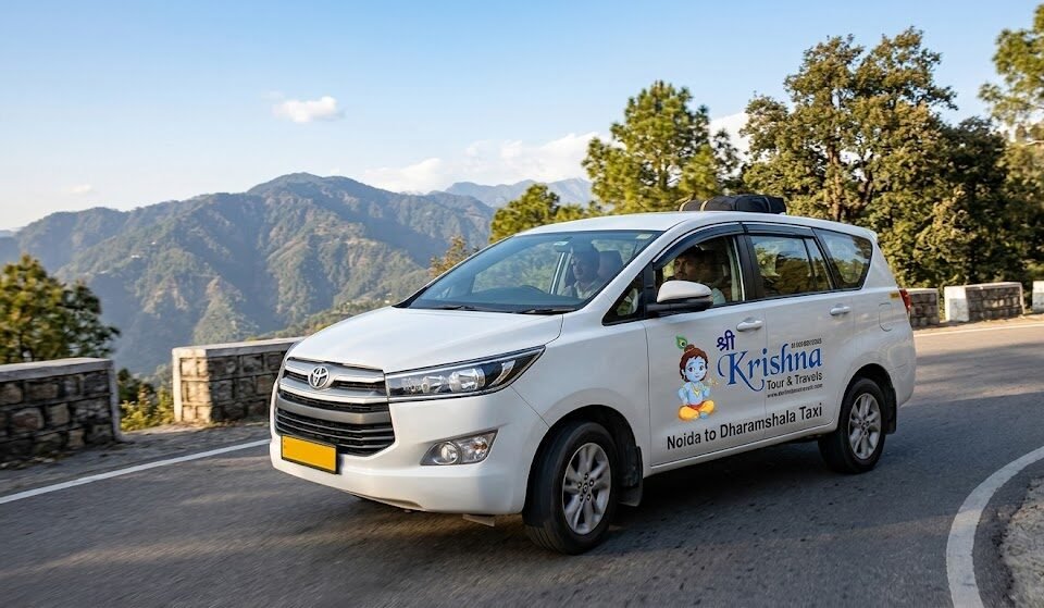 modern innova crysta suv noida to dharamshala taxi navigating mountain road near dharamshala with shri krishna logo